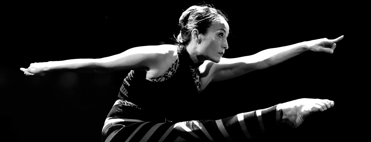 A photograph of Hee Ra Yoo dancing on a city street.