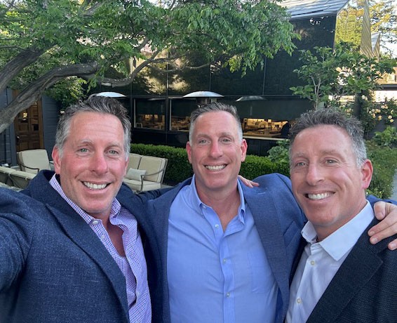 The Aronson brothers take a selfie in blue suit jackets and nice shirts.