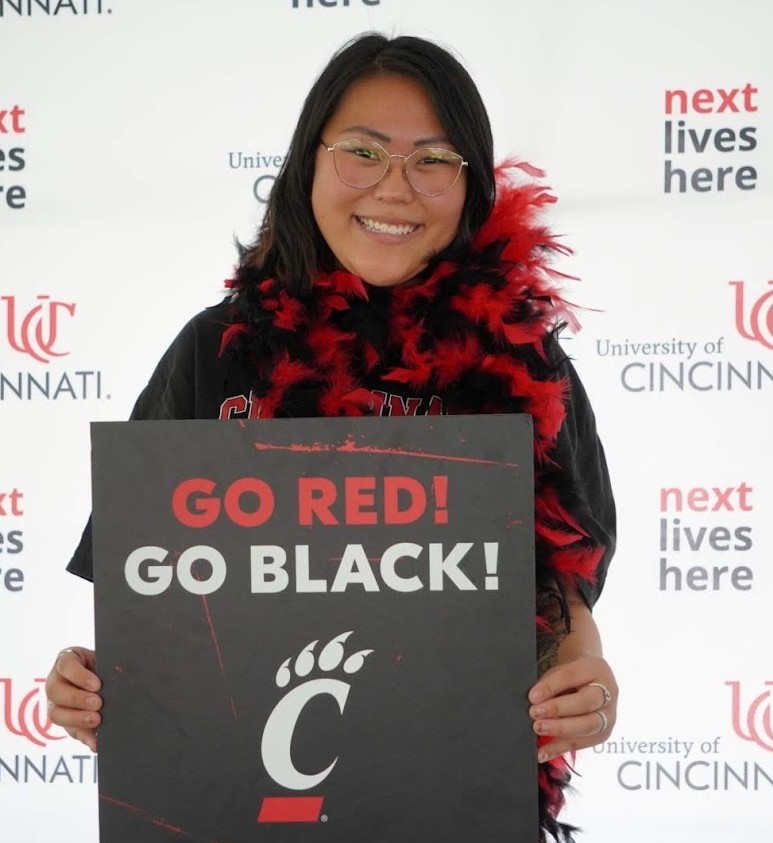 Gracie in front of UC signage