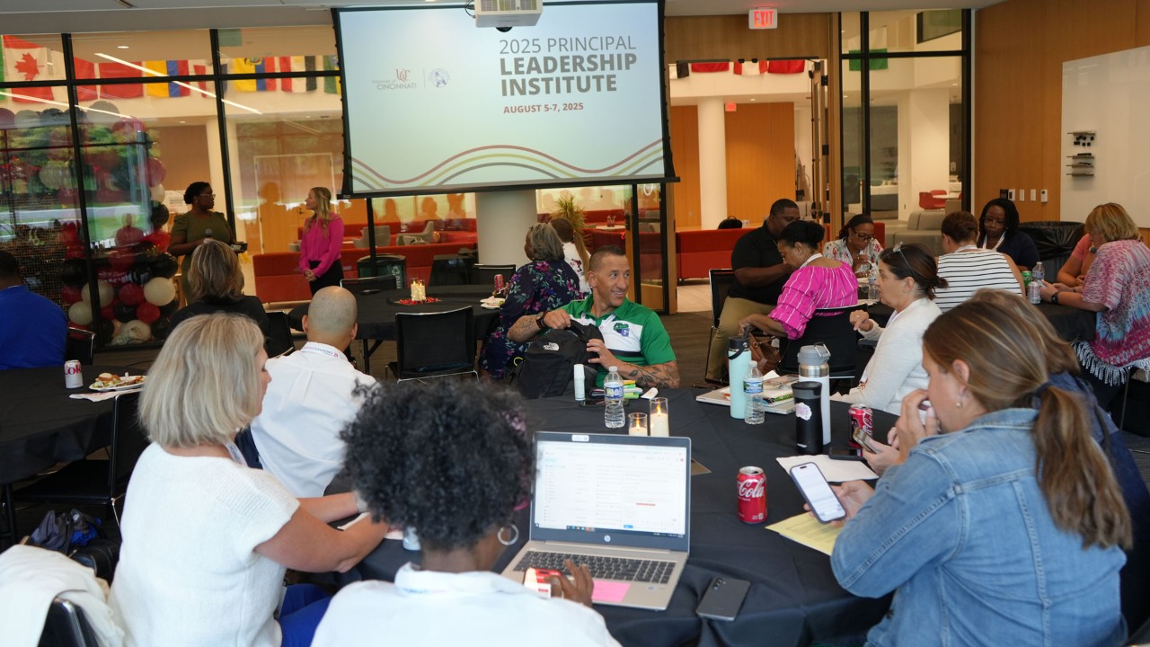 School principals sit around a table during a presentation