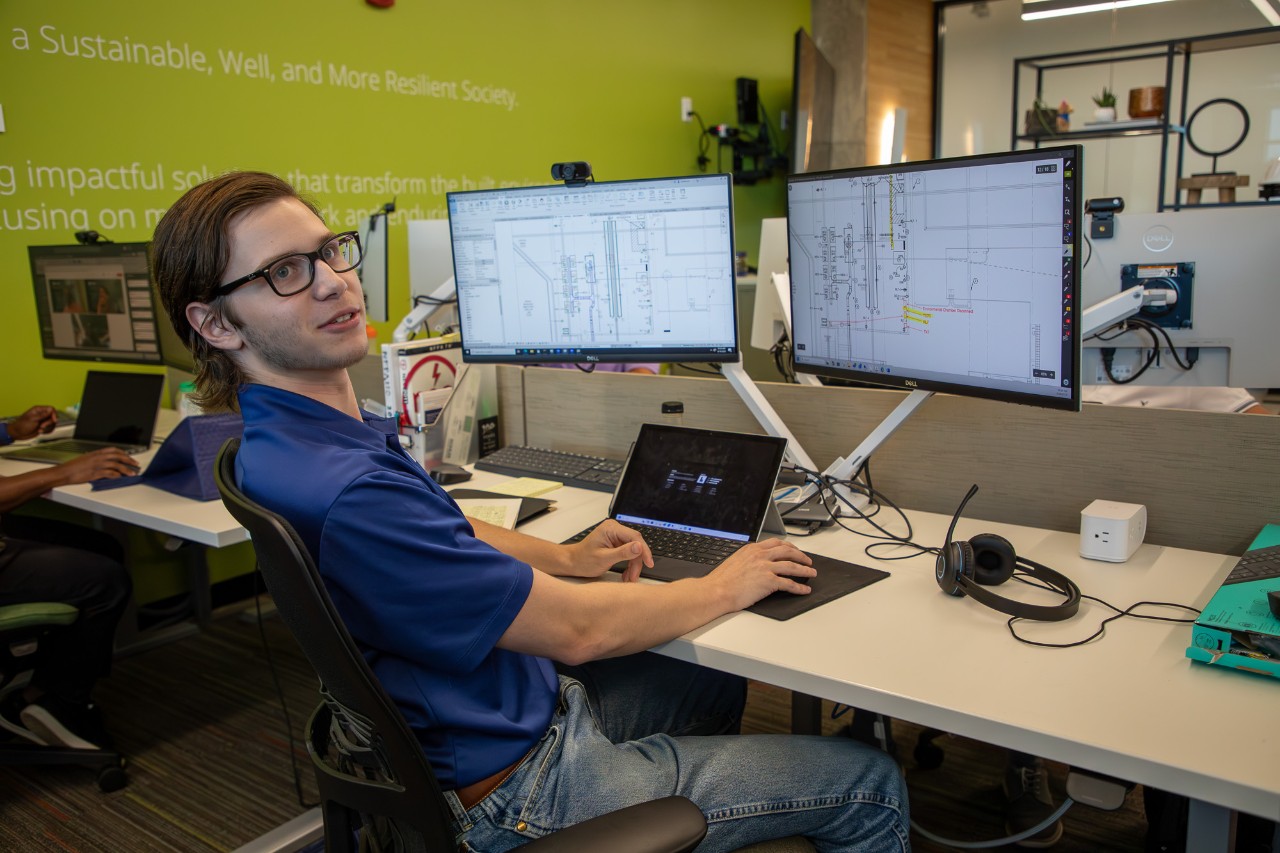 Owen Halburnt works on a plumbing project at his desk at HEAPY.