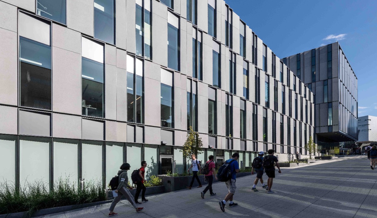 Students walk in front of the exterior of Lindner Hall.