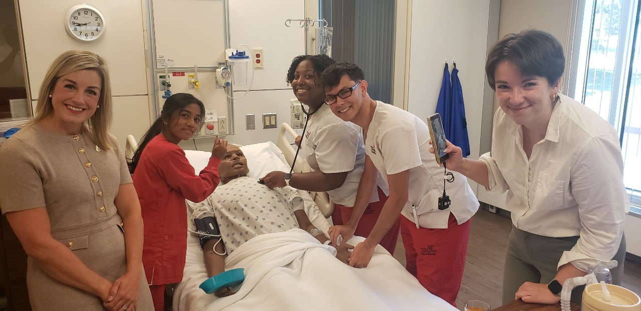 Dr. Lindsday Davis, far left, is shown with three UC nursing students in the College of Nursing Simulation Lab and Josie Masset of Think TV