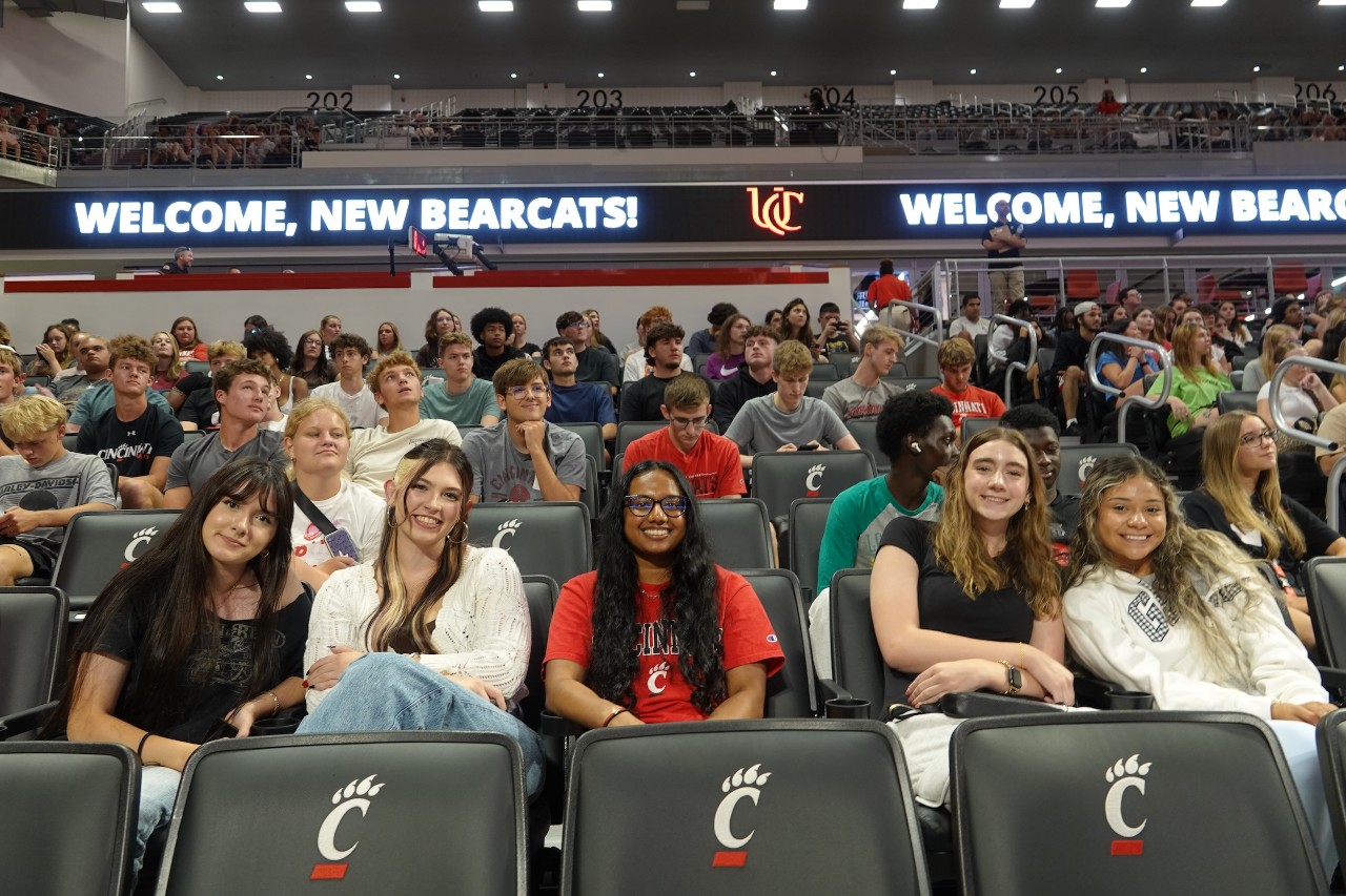 scores of students sitting in Fifth Third Arena posing for a photo