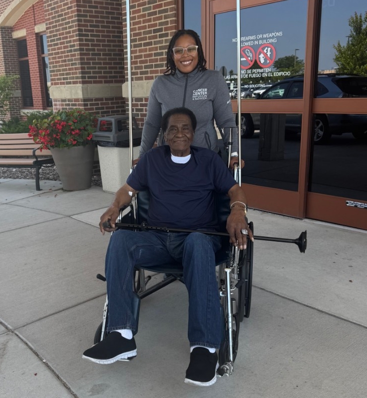 woman pushing man in wheelchair