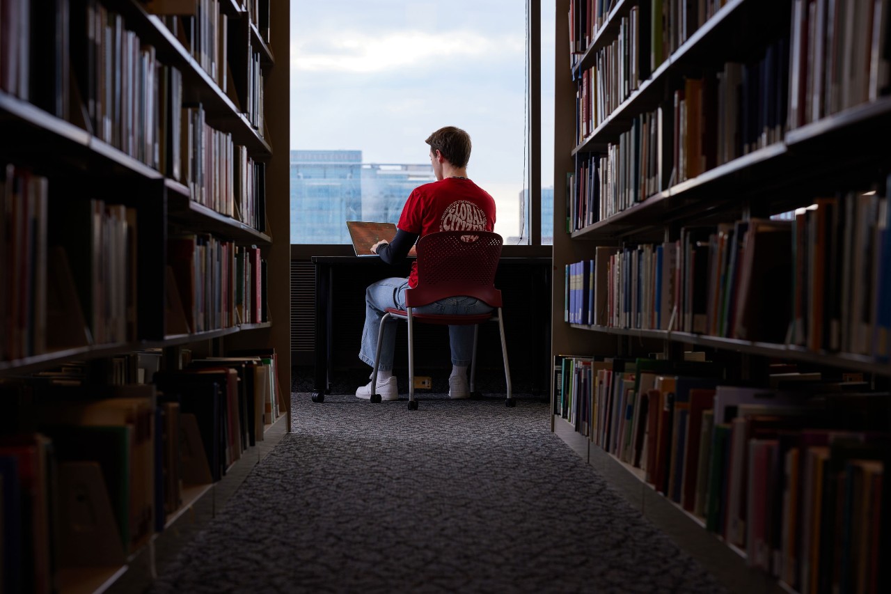 UC student on laptop in a library