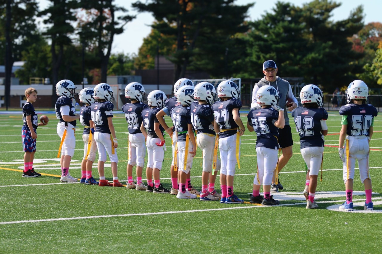 Flag football team lines up for high fives.