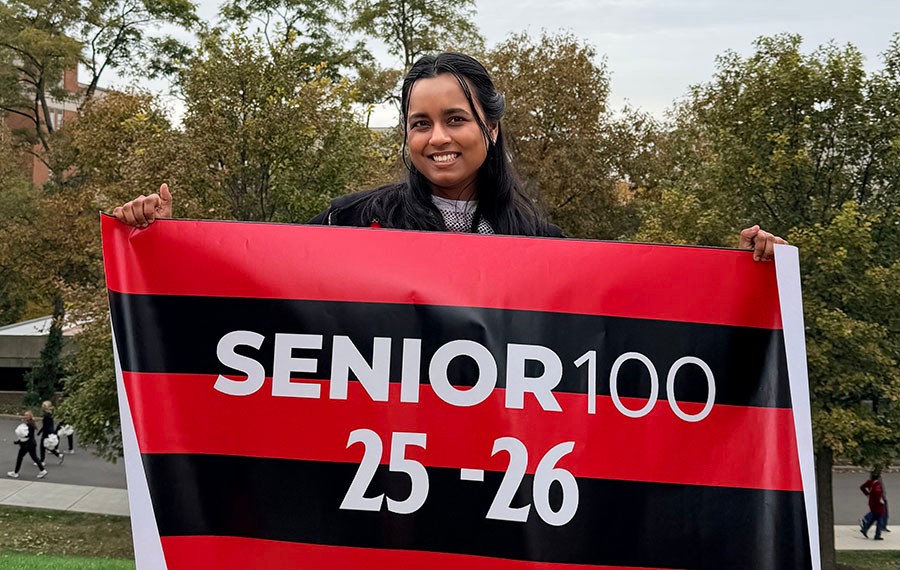 Ishika Yadavalli poses with a "Senior 100" banner