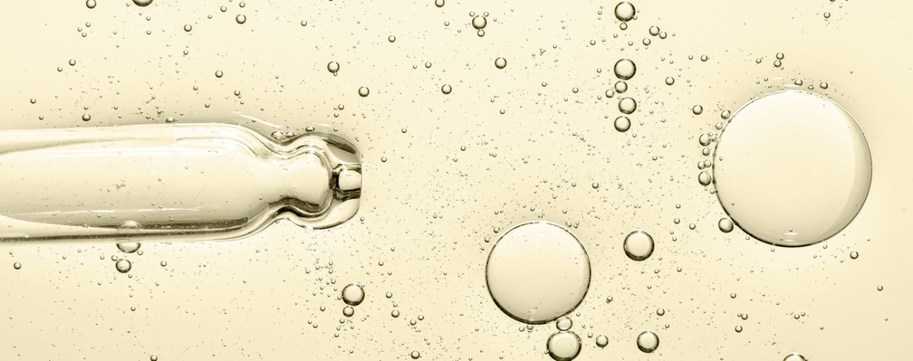 A close-up image of skin moisturizer bubbles and a pipette