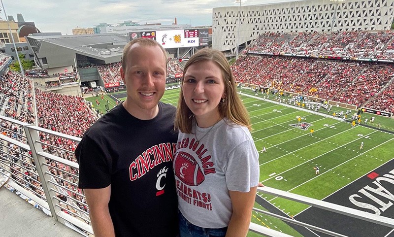 Erica Neff and husband pose in Nippert Stadium during a UC Bearcats football game