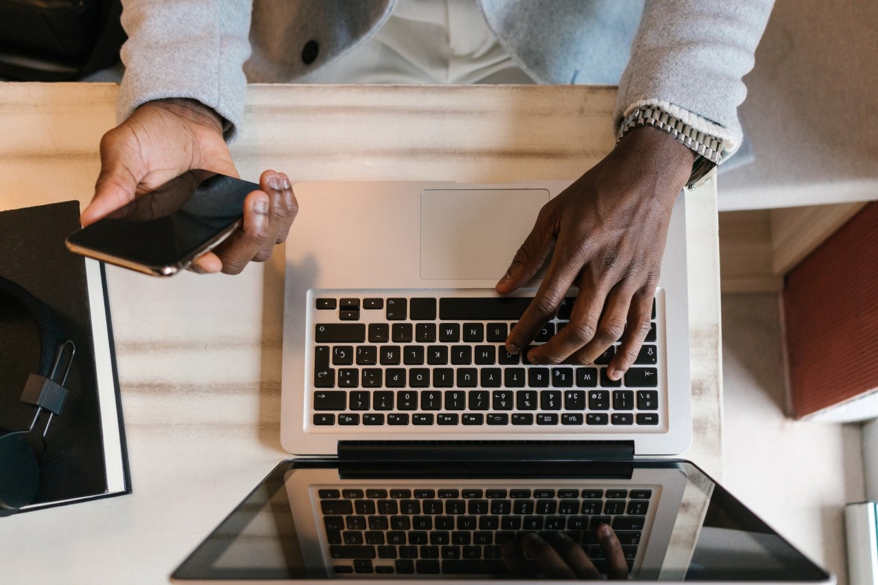 person using a mobile device to authenticate on their laptop