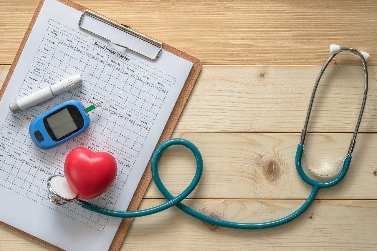Blood drop examination tool kit, blood sugar tracker record and heart with doctor's stethoscope