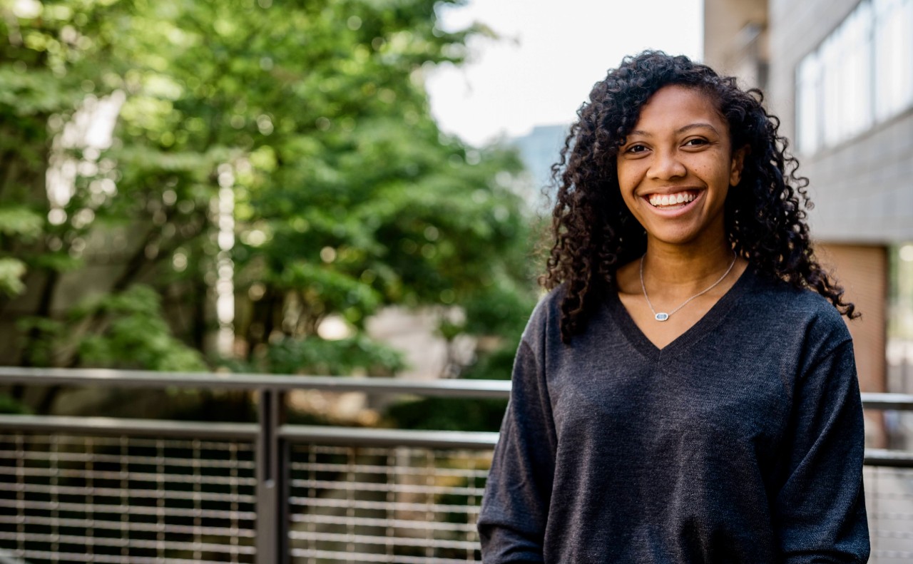 UC's Nicole Baah stands in front of a building on UC's campus.