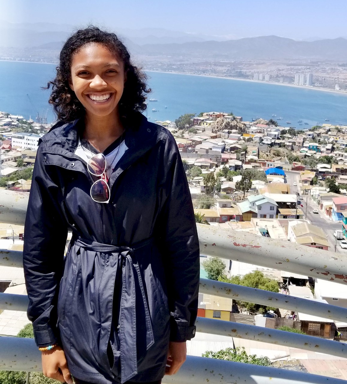 UC's Nicole Baah stands on a bridge surrounded by ocean and buildings in Santiago, Chile.