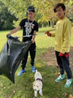 two teenagers pick up trash in a park
