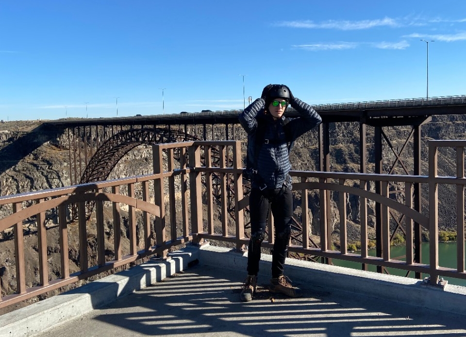 Jake Hemmerle adjusts his helmet while standing atop a gorge.