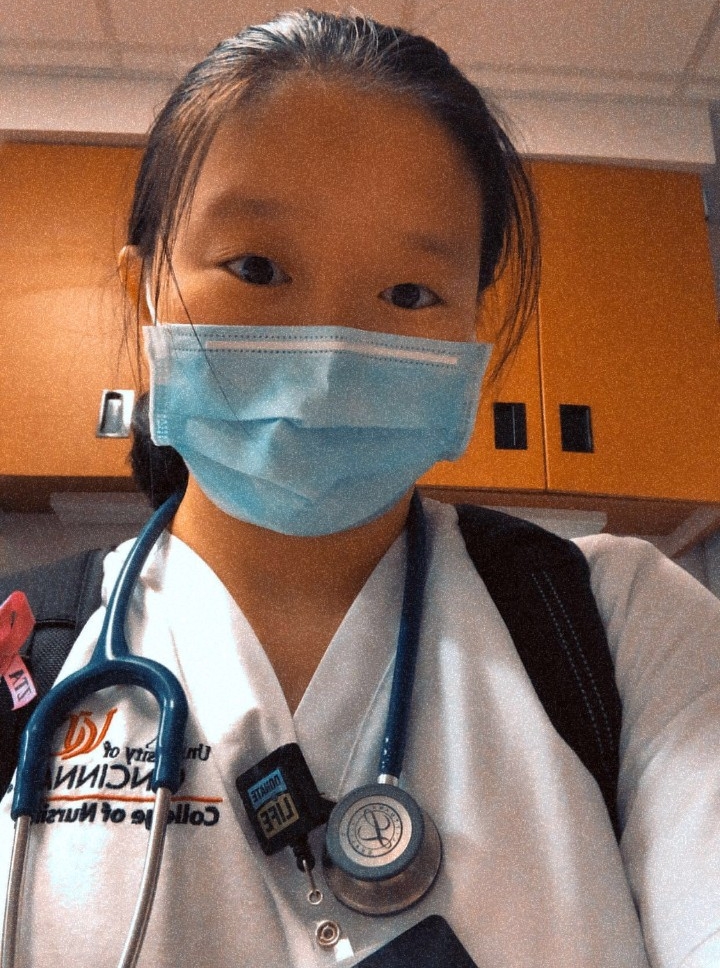 Zhong wearing a mask and scrubs, taking a selfie in the hospital