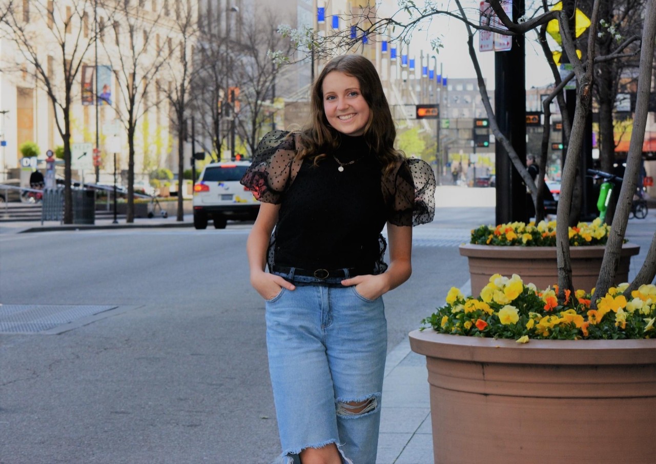 Jenna McMullen poses for a photo on a city street.