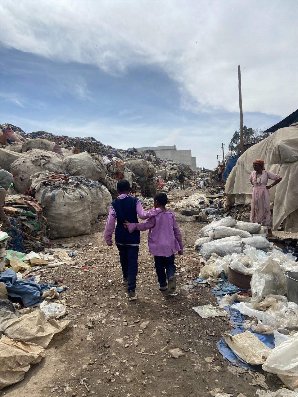 Children walk near piles of trash in Addis Ababa, Ethiopia.