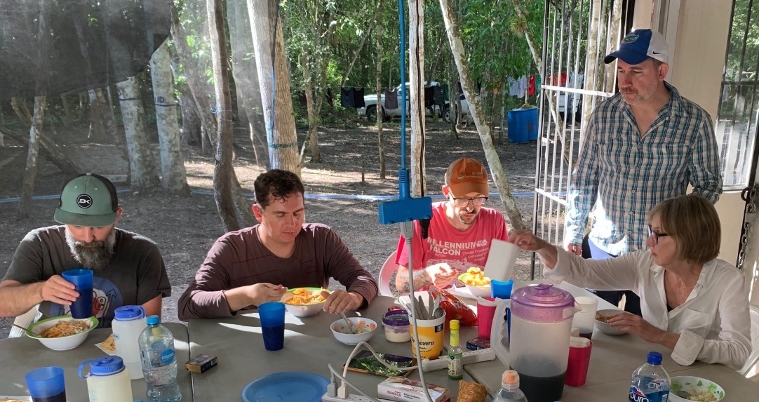 People sit around a table enjoying dinner.