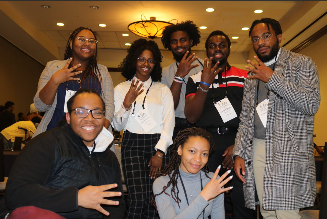 UC NSBE students hold up the number 4 at the convention