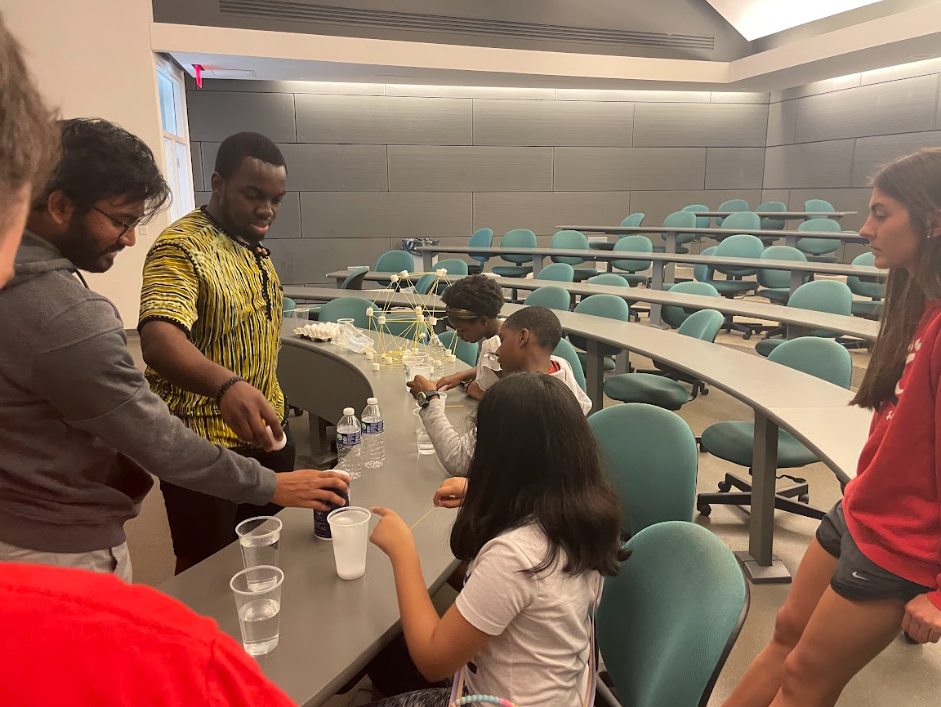 K-12 students work on engineering activity while NSBE students supervise.