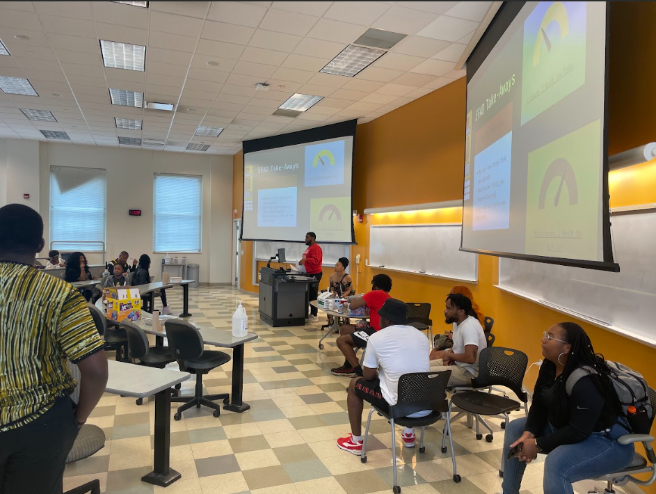 NSBE students sit in a classroom. Behind them a board reads "EFAD takeaways"