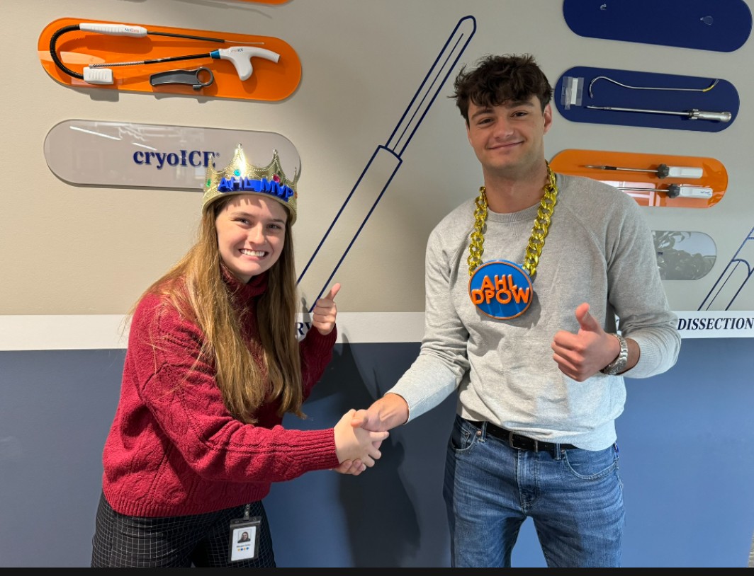 Morgan Carey (left) and another co-op student shake hands and give a thumbs up after winning awards in the Atricure basketball league