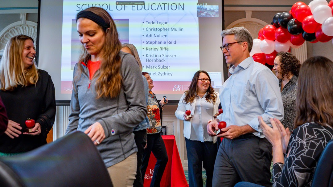 Academic professionals hold apple shaped awards