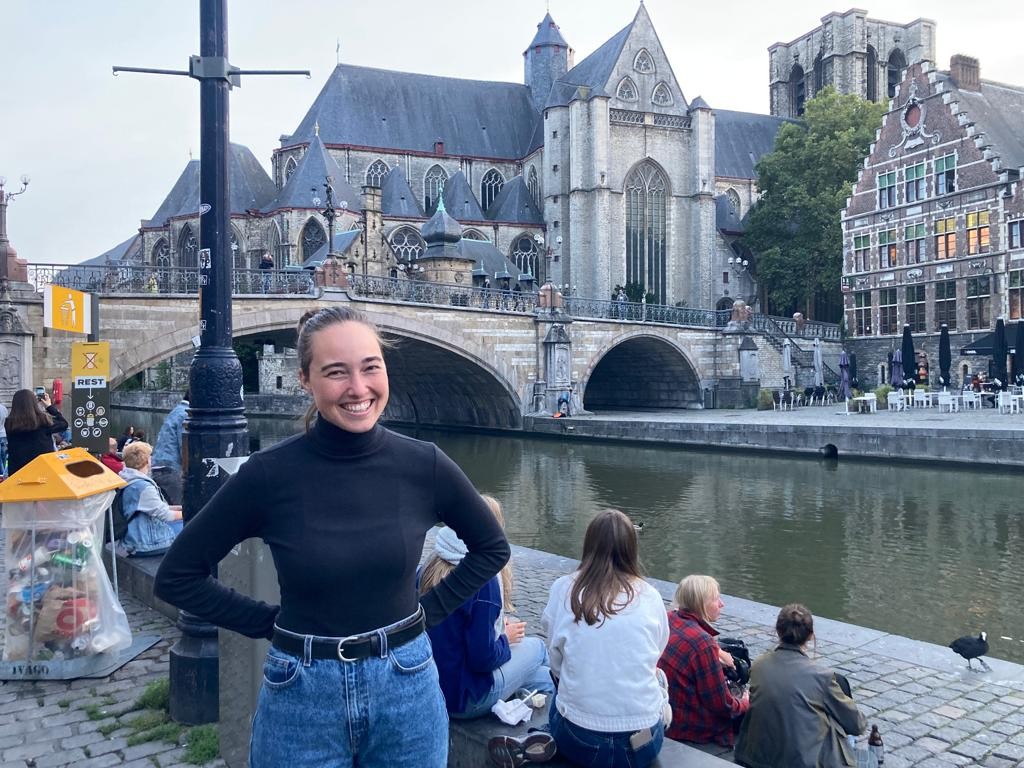 Lynn Pickering stands in front of a bridge that crosses a river in the city of Ghent, Belgium.