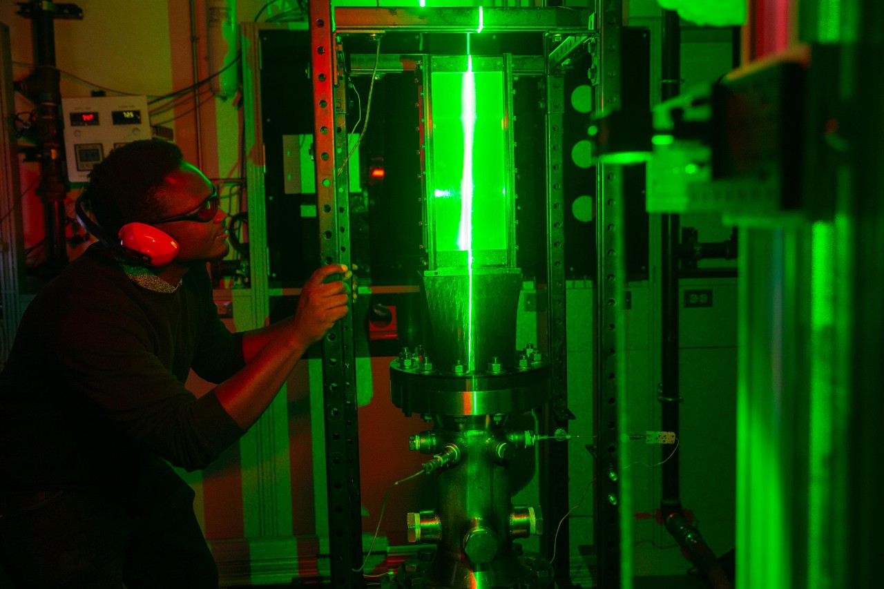 UC Aerospace Engineering student Vincent Onoja and UC Professor Daniel Cuppoletti (not pictured) developed a novel way to test the air flow in a jet engine nozzle using lasers and high-speed cameras. (Also pictured is doctoral student Keerthan Ganeshan)