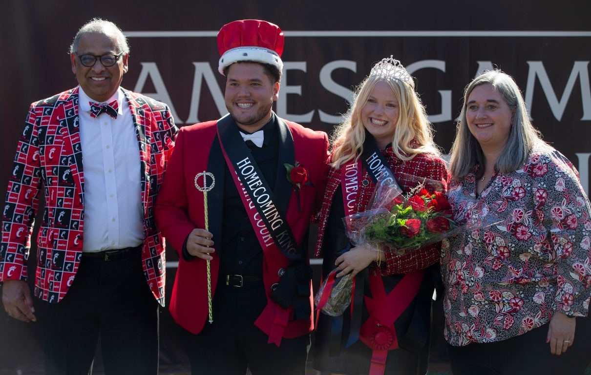 UC President Neville Pinto shown with Homecoming King and Queen during football game