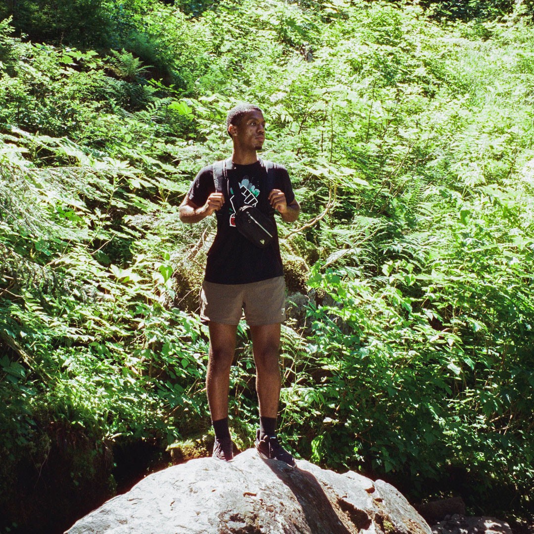 Siinboon Daba stands on a rock on a hike while traveling to Seattle.