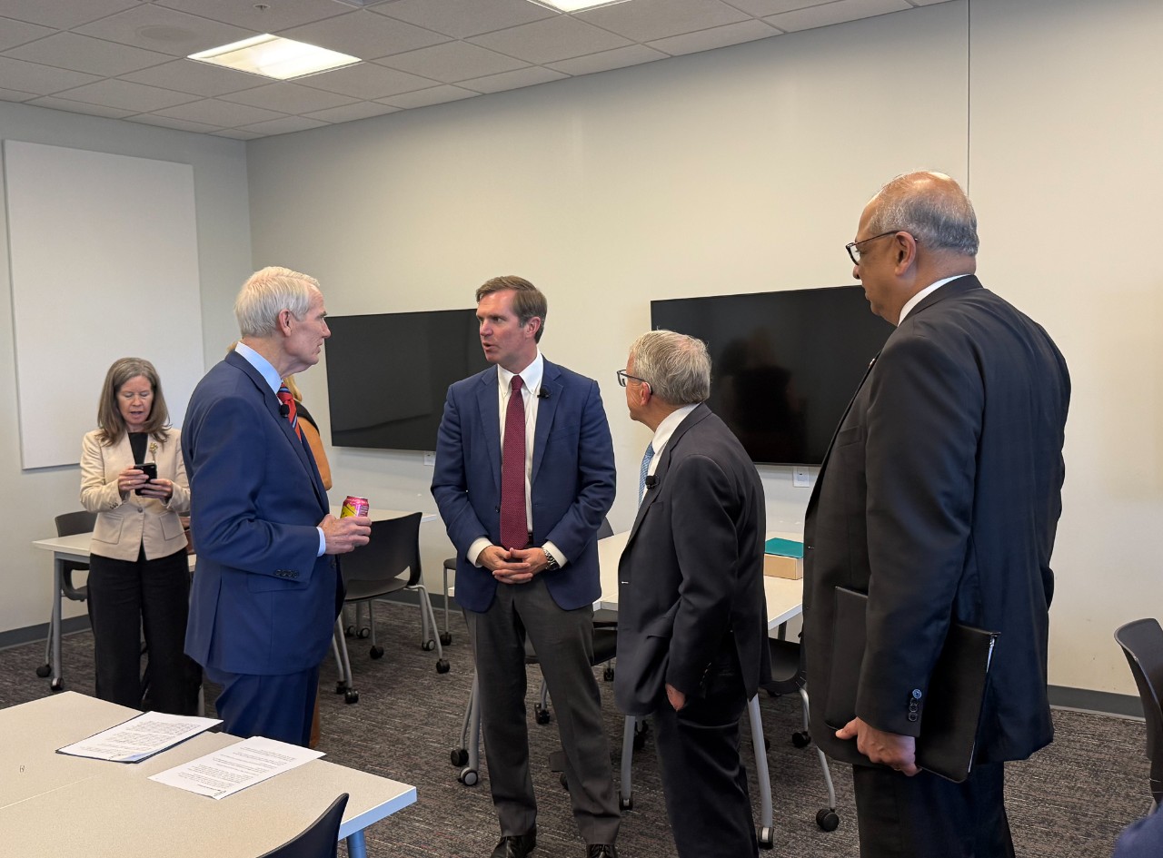 Neville Pinto talks to Mike DeWine, Andy Beshear and Rob Portman in a UC classroom.