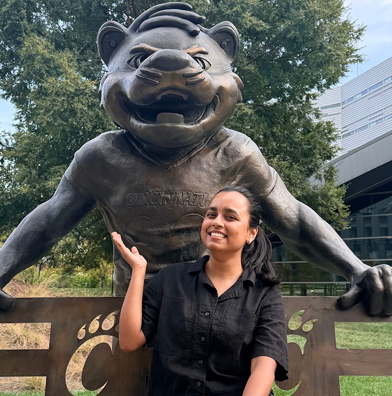 Ishika Yadavalli poses with the Bearcat statue on campus.